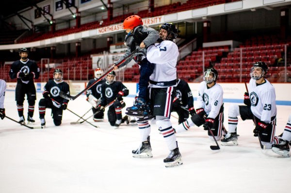 Marco Bozzo, a Huskies forward, celebrates a goal by 8-year-old Simon Valencia-Devin