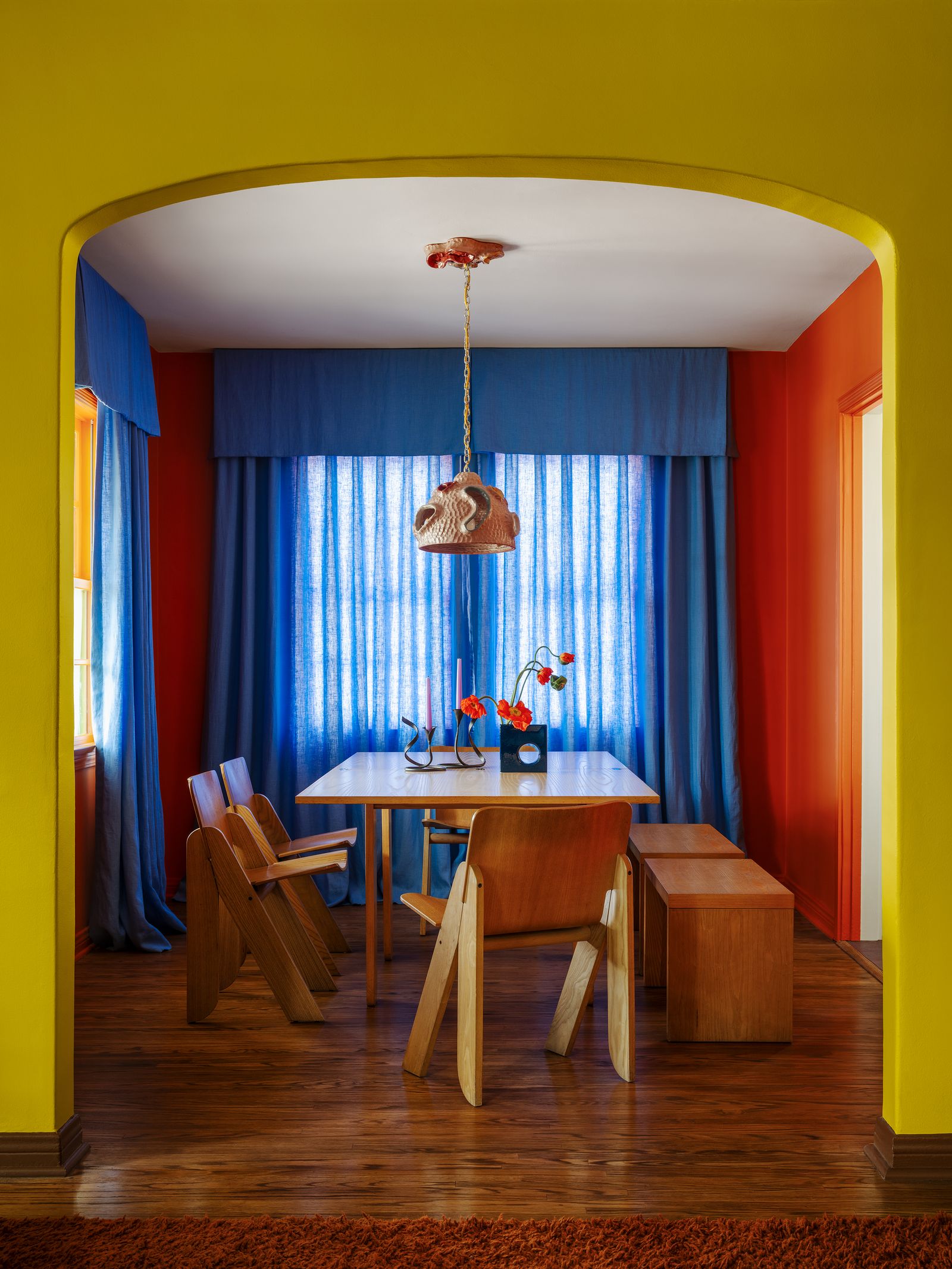 Blick durch gelbgrünen Bogen auf Esszimmer blaue Vorhänge