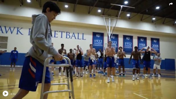 Bemberger walks across the court as the KU basketball team gives him a round of applause