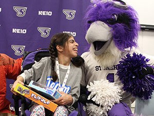 Team Impact member smiles at the Stonehill mascot in celebration