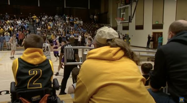 Zach Heckinger watches the basketball game from the sideline