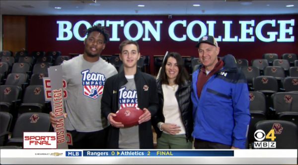 Zion and Jack smile and pose for a photo while sporting Team Impact gear